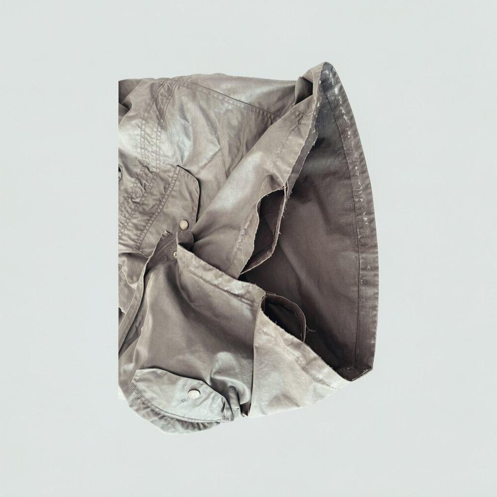Wax jacket pocket and hem before repair, torn fabric